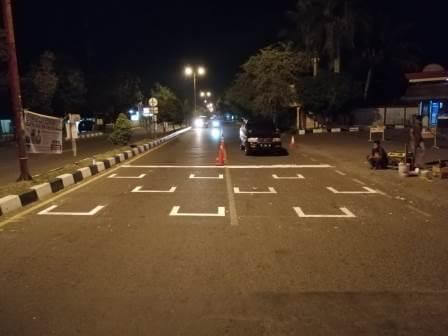 Batas jaga jarak kendaraan ditandai dengan cat di badan jalan depan traffic light (lampu merah) di Banda Aceh