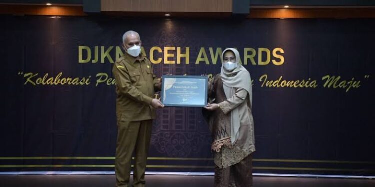 Kakanwil DJKN Aceh Syukriah HG menyerahkan piagam penghargaan kepada Pemerintah Aceh Kategori Kolaboratif Dukungan Pemerintah Daerah Dalam Pengelolaan Aset Negara yang diterima Sekda Aceh Taqwallah, pada acara DJKN Aceh Award 2021, di Gedung DJKN Kanwil Aceh, Selasa (25/1)