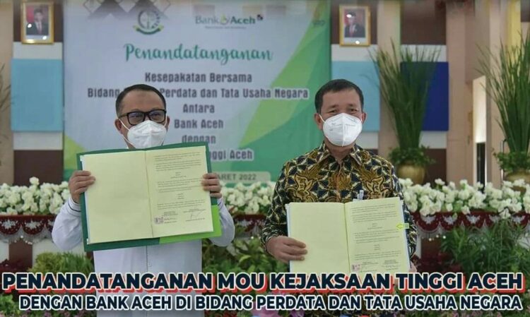 Kajati Aceh Bambang Bachtiar SH MH dan Direktur Utama Bank Aceh Syariah Haizir Sulaiman memperlihatkan naskah kerja sama, sesaat setelah penandatanganan kesepakatan bersama Bidang Hukum Perdata dan Tata Usaha Negara, di Aula Kejati Aceh, Rabu (9/3)