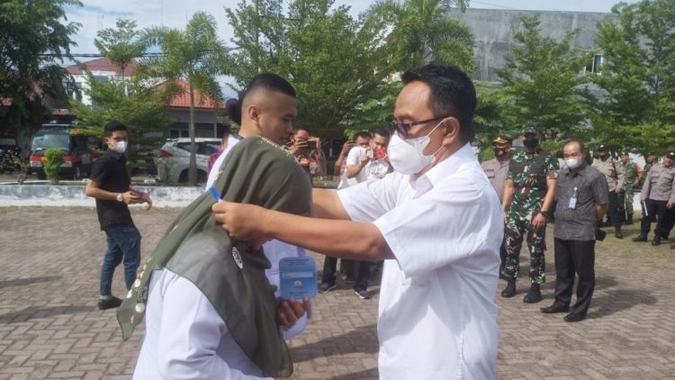 Kadis Peternakan Aceh Zalsufran ST MSi mengalungkan bad peserta saat melepas Tim Pengawasan Pemotongan Hewan Qurban Idul Adha 1443 Hijriah, di halaman Kantor Disnak Aceh, Jum'at (8/7)