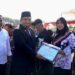 Pj Bupati Aceh Besar Muhammad Iswanto menyerahkan penghargaan kepada guru pada upacara peringatan HGN dan HUT ke-77 PGRI di Lapangan Angkasa Pura, Blang Bintang, Sabtu (26/11)