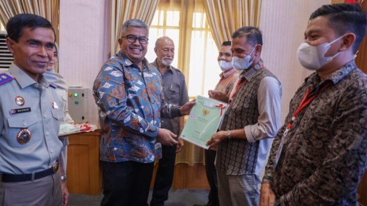 Sekda Aceh Bustami Hamzah bersama Wali Nanggroe Aceh Malik Mahmud Al-Haytar, Kakanwil BPN Aceh Mazwar menyerahkan secara simbolis sertipikat tanah kepada warga, di Aula BPSDM Aceh, Banda Aceh, Kamis (1/12)