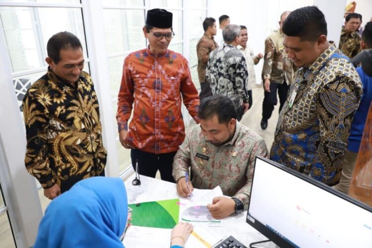 Pj Bupati Aceh Besar Muhammad Iswanto membuka tabungan didampingi Plt Dirut Bank Aceh Syariah Bob Rinaldi saat peresmian Bank Aceh Syariah Capem Seulimuem, Aceh Besar, Kamis (5/1)