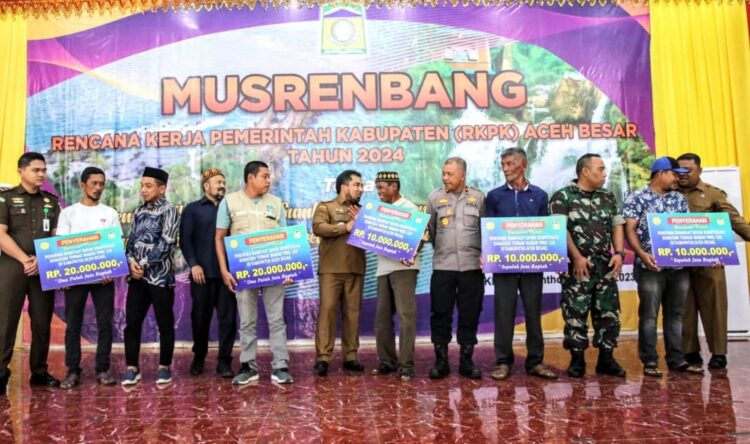 Pj Bupati Aceh Besar Muhammad Iswanto menyerahkan bantuan kepada penerima manfaat kompensasi kematian ternak akibat wabah PMK/LSD di Aceh Besar, Senin (13/3)
