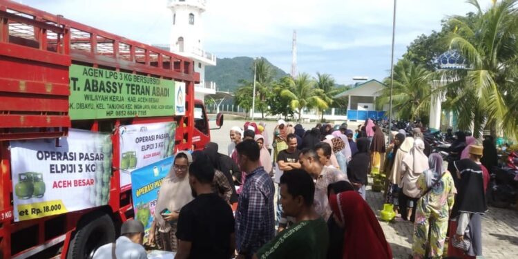 Masyarakat Peukan Bada menyerbu mobil yang membawa tabung gas elpiji 3 kg pada operasi pasar di halaman Masjid Teungku Chik Mahraja Gurah, Kecamatan Peukan Bada, Senin (1/5)