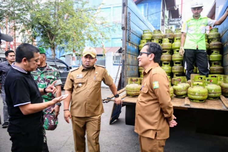 Pj Bupati Aceh Besar Muhammad Iswanto didampingi Kepala Dinas Koperasi dan UMKM Aceh Besar Darmansyah memantau operasi pasar murah Gas Elpiji 3 Kg, di halaman Meunasah, Lambaro, Kecamatan Ingin Jaya, Selasa (2/5)