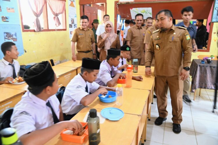 Pj Bupati Aceh Besar Muhammad Iswanto saat menghadiri peluncuran simulasi program makan siang gratis bagi pelajar SMP Negeri 1 Darul Imarah, Aceh Besar, Selasa (5/3)