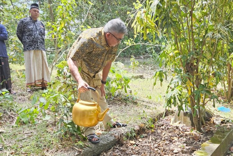 Pj Gubernur Aceh Bustami Hamzah berziarah ke makam orang tua laki-lakinya di Gampong Nicah, Kecamatan Grong-grong, Pidie, Jum'at siang (12/4/2024). Terlihat Bustami sedang menyiram air ke pusara kuburan orang tuanya