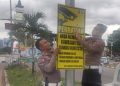 Personel Ditlantas Polda Aceh memasang papan rambu peringatan ETLE di sejumlah titik traffic light (lampu lalu lintas) dalam Kota Banda Aceh, Jum'at (3/5)