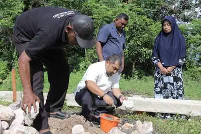 Pj Bupati Aceh Besar Muhammad Iswanto melakukan peletakan batu pertama pembangunan rumah Aminah, yang berdomisili di Gampong Bukit Meusara, Kecamatan Kota Jantho, Jum'at (17/5/2024). (Foto: For Infoaceh.net)