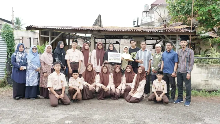 Keluarga Besar MTsN 1 Model Banda Aceh menyantuni salah satu siswi madrasah itu yang rumahnya terbakar di Aspol Lamteumen. Foto: Istimewa