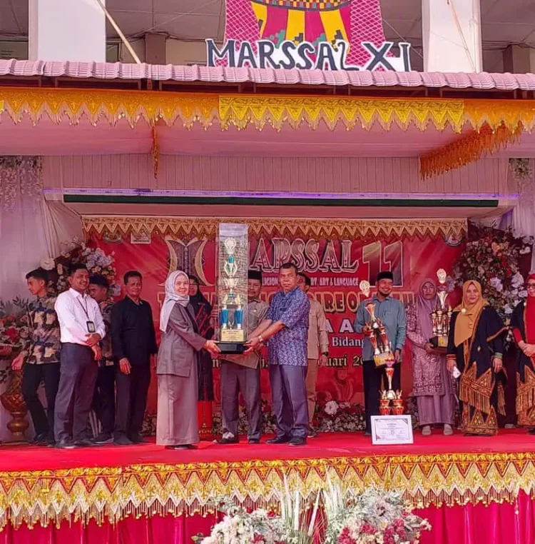 Kepala MIN 6 Banda Aceh Bukhari SPd MPd didampingi Ketua Komite Sekolah Qamaruzzaman Haqny, menerima piala bergilir juara umum Marssal XI MTsN 1 Model Banda Aceh, Kamis (6/2). (Foto: Dok. Infoaceh.net)