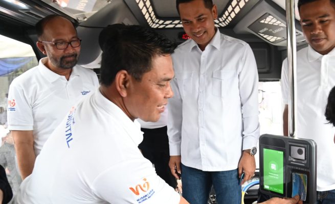 Bupati Aceh Besar Syech Muharram Idris menempelkan kartu Trans Koetaradja dalam acara peluncuran aplikasi Trans Koetaradja di Terminal Tipe A Batoh, Banda Aceh, Ahad (4/5)
