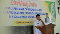 Bupati Aceh Besar Muharram Idris menyampaikan sambutannya pada sosialisasi fatwa dan hukum Islam di Meunasah Gampong Lam Geu Eu, Peukan Bada, Rabu (7/5)