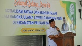 Bupati Aceh Besar Muharram Idris menyampaikan sambutannya pada sosialisasi fatwa dan hukum Islam di Meunasah Gampong Lam Geu Eu, Peukan Bada, Rabu (7/5)