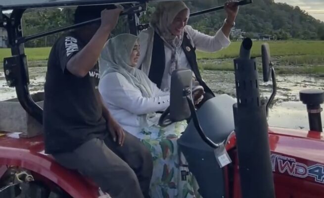 Ketua Tim Penggerak PKK Aceh Selatan, Devina Mirwan, yang juga istri Bupati Aceh Selatan Mirwan, turun langsung mengemudikan traktor membajak sawah