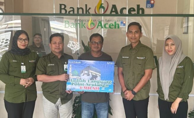 Pemimpin Bank Aceh Cabang Idi Rayeuk, Samsul Bahri didampingi Pimpinan Capem Julok Iskandar menyerahkan hadiah umrah kepada nasabah. (Foto: Ist)
