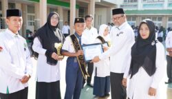 Kakankemenag Kota Banda Aceh Salman Arifin menyematkan selempang kepada dua siswa MTsN 1 Model Banda Aceh yang terpilih sebagai Duta Literasi dalam program Gerakan Literasi Madrasah (GELIMA)