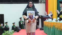 Fitri Ermawati, ibu dari almarhum Jodi Ramadhansyah menerima ijazah pada wisuda Angkatan ke-165 USK di Gedung AAC Dayan Dawood, Rabu (28/5/2025). (Foto: Dok. USK Banda Aceh)