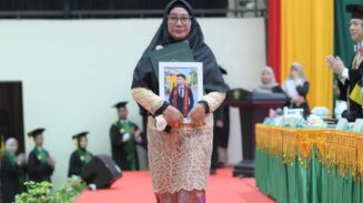 Fitri Ermawati, ibu dari almarhum Jodi Ramadhansyah menerima ijazah pada wisuda Angkatan ke-165 USK di Gedung AAC Dayan Dawood, Rabu (28/5/2025). (Foto: Dok. USK Banda Aceh)