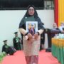 Fitri Ermawati, ibu dari almarhum Jodi Ramadhansyah menerima ijazah pada wisuda Angkatan ke-165 USK di Gedung AAC Dayan Dawood, Rabu (28/5/2025). (Foto: Dok. USK Banda Aceh)