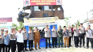 Sebuah mobil dan sepeda motor korban kecelakaan lalu lintas terpajang di atas sebuah monumen, di depan Polsek Julok, Polres Aceh Timur