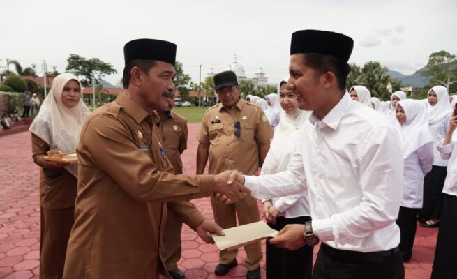 Wakil Bupati Aceh Besar Syukri A Jalil menyerahkan SK pengangkatan 88 CPNS di halaman kantor Bupati Aceh Besar, Kota Jantho, Selasa (3/6).
