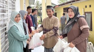 Kepala SMAN 15 Adidarma, Zulfikar menyerahkan daging kurban yang berlangsung di halaman sekolah setempat, Gampong Mulia, Kecamatan Kuta Alam, Banda Aceh, Ahad (8/6).