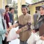 Kepala SMAN 15 Adidarma, Zulfikar menyerahkan daging kurban yang berlangsung di halaman sekolah setempat, Gampong Mulia, Kecamatan Kuta Alam, Banda Aceh, Ahad (8/6).