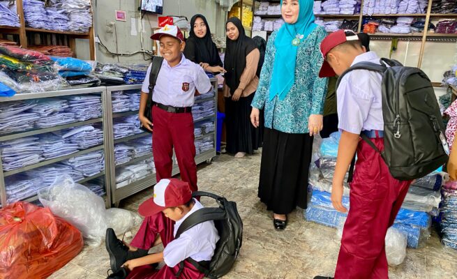 Marlina Usman, Bunda PAUD Aceh, membantu memilihkan sepatu dan seragam baru untuk 3 siswa SD di Blangpidie, Selasa (17/6). Aksi spontan ini dilakukan setelah ia melihat sepatu lusuh yang mereka kenakan. (Foto: For Infoaceh.net)