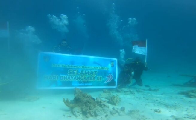 Ditpolairud Polda Aceh mengibarkan bendera Merah Putih di dasar laut perairan Sabang, Sabtu, 28 Juni 2025. (Foto: Ist)