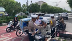 Satlantas Polresta Banda Aceh membagikan puluhan helm secara gratis kepada pengendara sepeda motor, Senin (21/7). (Foto: Ist)