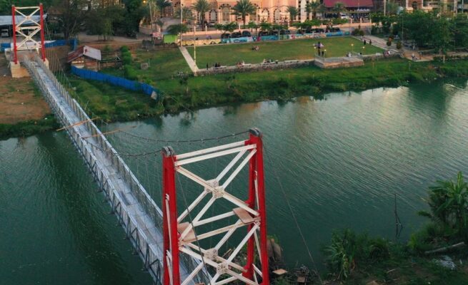 Jembatan gantung yang menghubungkan Gampong Lambhuk Kecamatan Ulee Kareng dan Gampong Lamseupeung Kecamatan Lueng Bata, Banda Aceh dengan latar belakang Masjid Haji Keuchik Leumiek. (Foto: Ist)