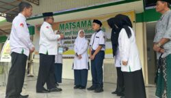 Kakanwil Kemenag Aceh Azhari didampingi Kepala MTsN 1 Banda Aceh Hj Ummiyani SAg MPd dan ketua komite menyematkan tanda peserta kepada dua perwakilan siswa, Senin, 14 Juli 2025. (Foto: Ist)