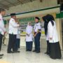 Kakanwil Kemenag Aceh Azhari didampingi Kepala MTsN 1 Banda Aceh Hj Ummiyani SAg MPd dan ketua komite menyematkan tanda peserta kepada dua perwakilan siswa, Senin, 14 Juli 2025. (Foto: Ist)