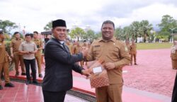 Bupati Aceh Besar Muharram Idris atau Syech Muharram menyerahkan SK Plt Kadiskopukmdag Aceh Besar kepada Drs Sulaimi MSi di halaman Kantor Bupati Aceh Besar, Kota Jantho, Senin (14/7). (Foto: Ist)