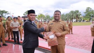 Bupati Aceh Besar Muharram Idris atau Syech Muharram menyerahkan SK Plt Kadiskopukmdag Aceh Besar kepada Drs Sulaimi MSi di halaman Kantor Bupati Aceh Besar, Kota Jantho, Senin (14/7). (Foto: Ist)