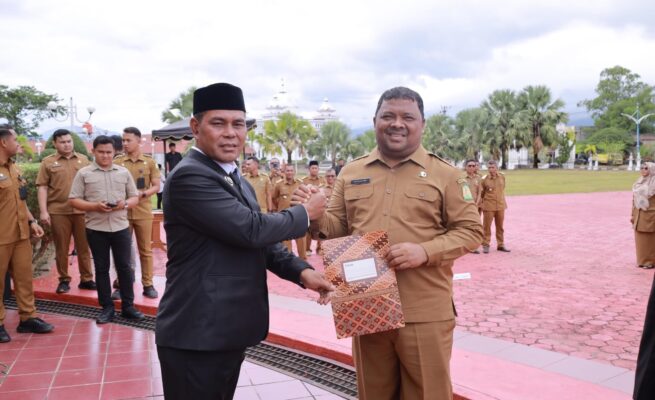 Bupati Aceh Besar Muharram Idris atau Syech Muharram menyerahkan SK Plt Kadiskopukmdag Aceh Besar kepada Drs Sulaimi MSi di halaman Kantor Bupati Aceh Besar, Kota Jantho, Senin (14/7). (Foto: Ist)